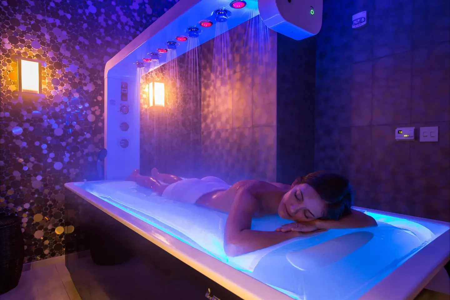Guest resting on a glowing spa water table at Fairmont Kea Lani Maui.