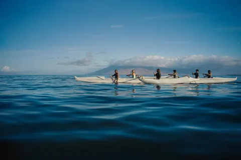 Group paddling an outrigger canoe offshore at Fairmont Kea Lani Maui.