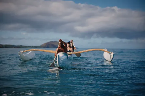 Two guests paddling an outrigger canoe off Fairmont Kea Lani Maui.