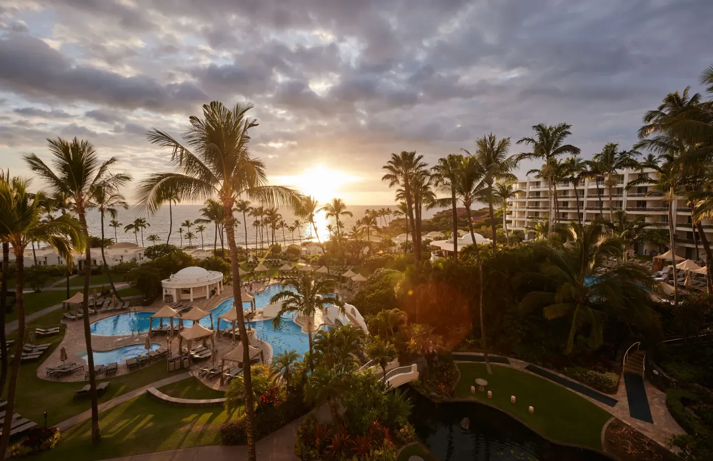 Sunset over palms, pools, gardens, and ocean at Fairmont Kea Lani Maui.