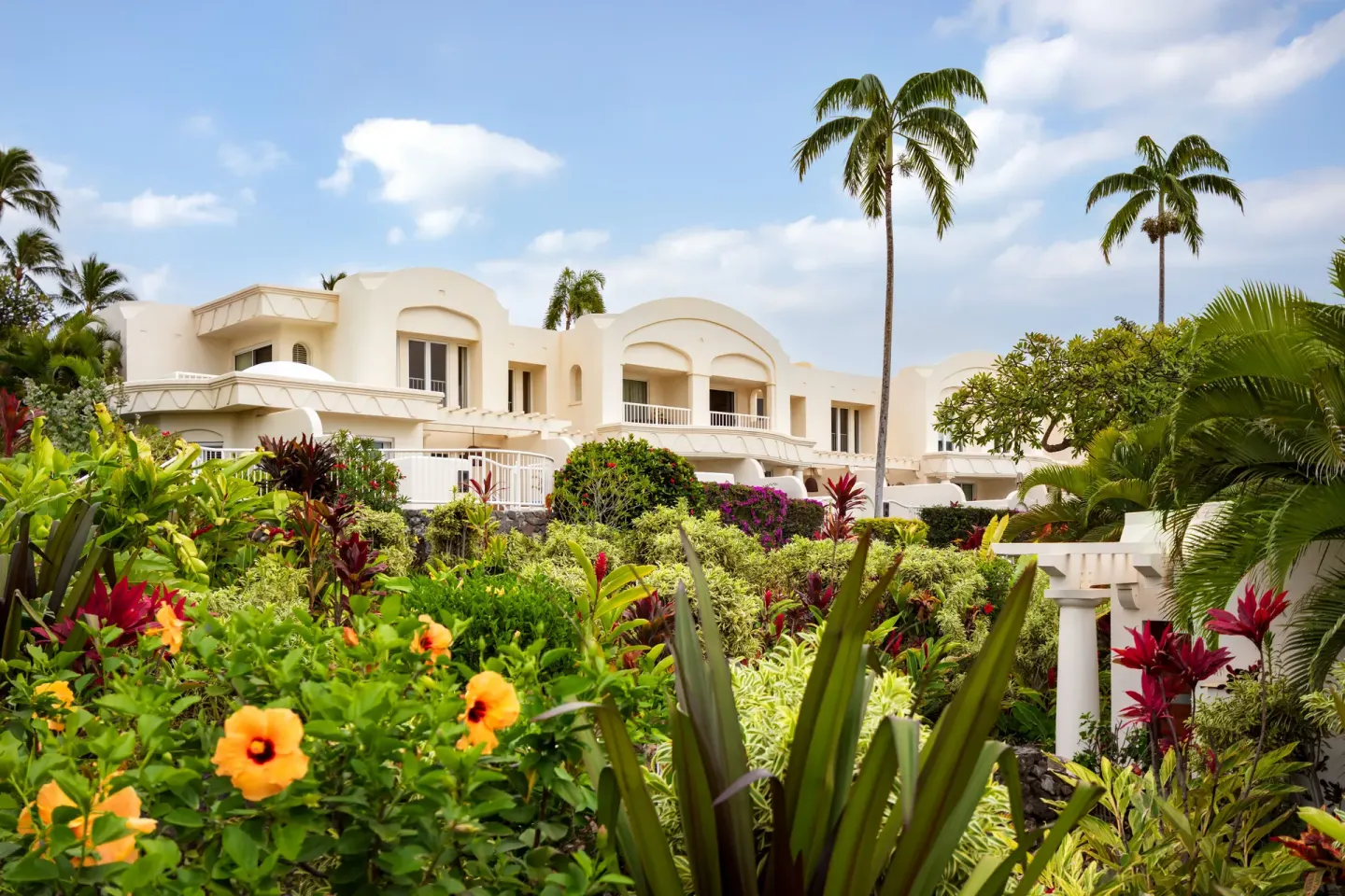 Tropical gardens and white resort buildings at Fairmont Kea Lani Maui.