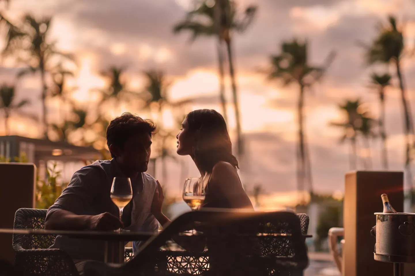 Couple with wine at sunset on an outdoor terrace at Fairmont Kea Lani Maui.