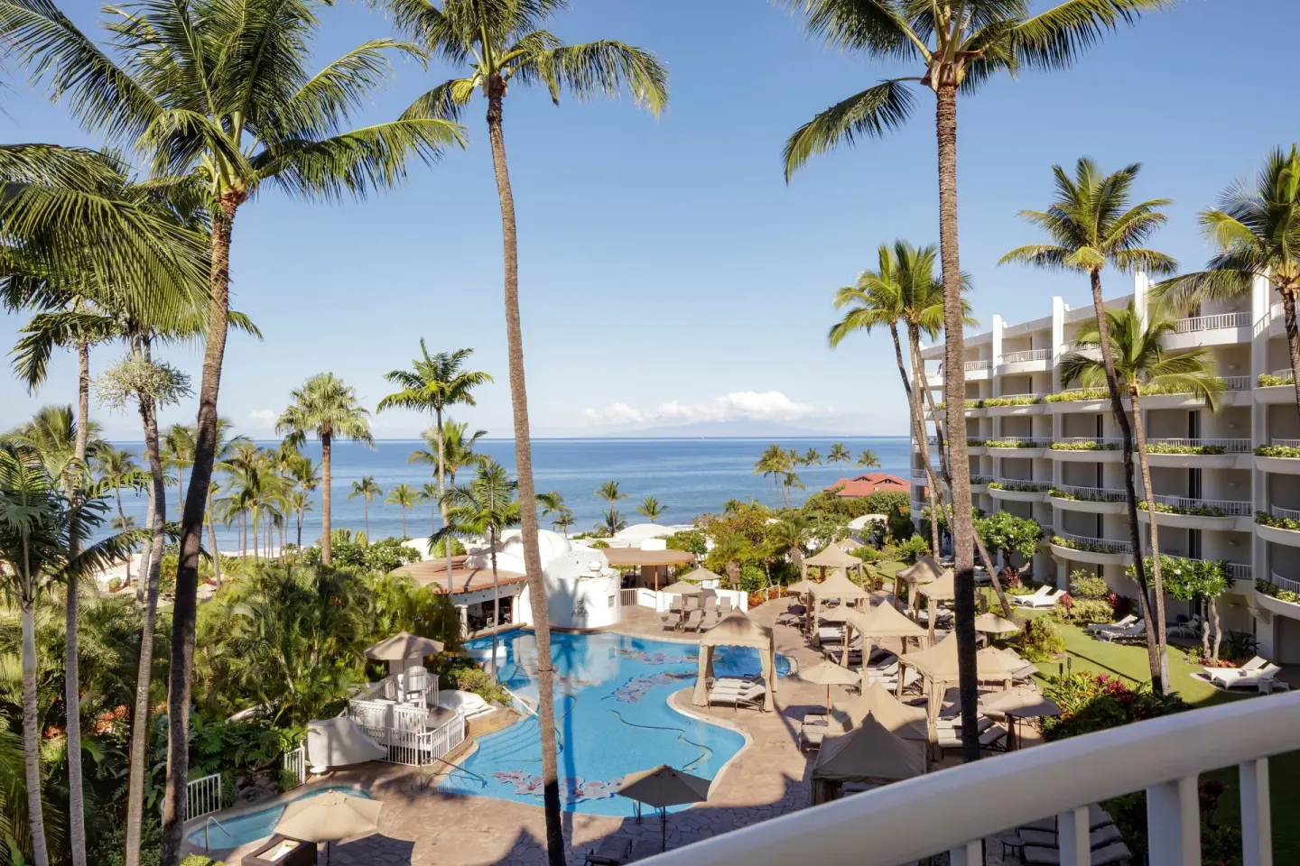 Ocean, pool and palms seen from a Deluxe Ocean View Suite at Fairmont Kea Lani Maui.