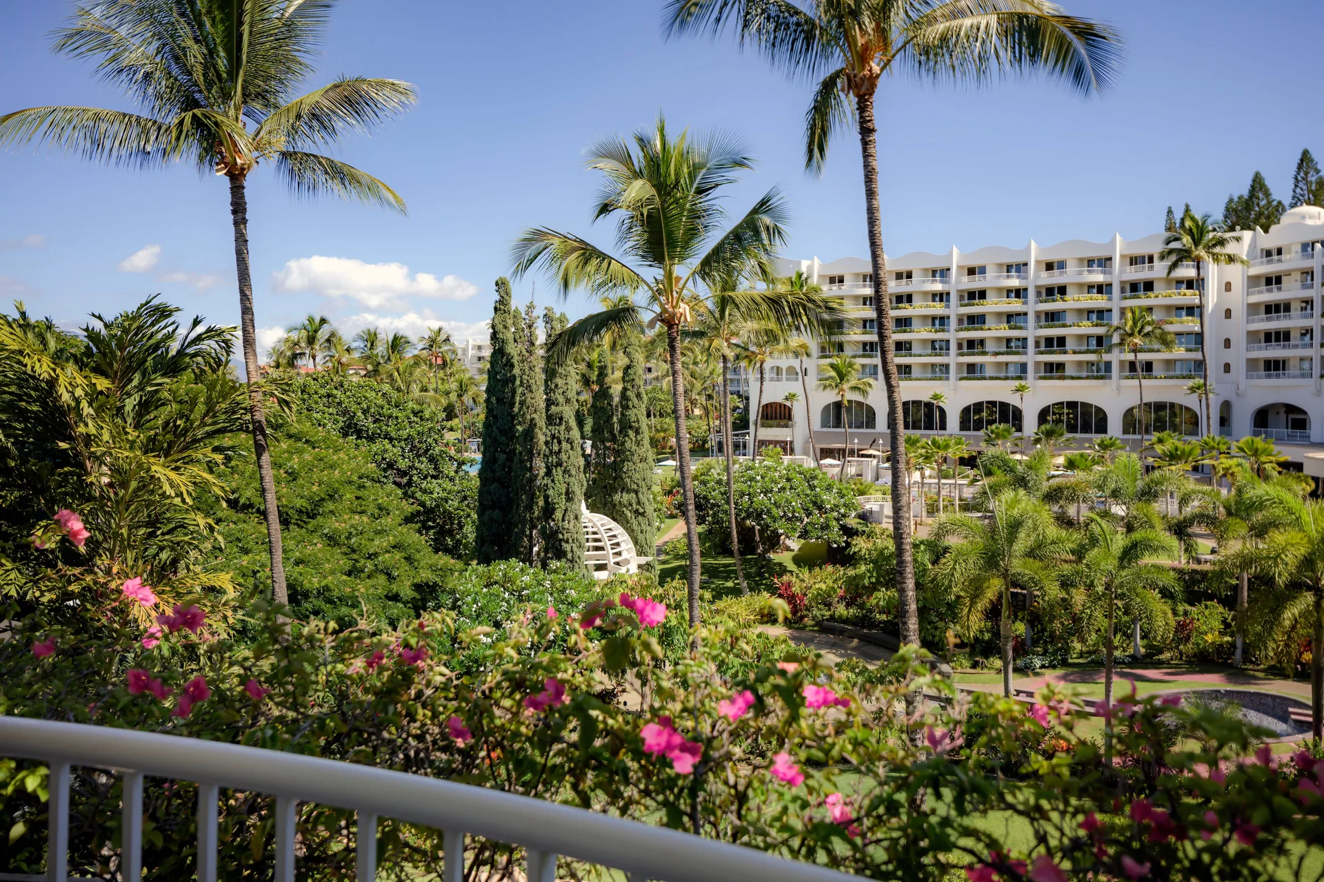 Garden View Suite balcony overlooks palms and flowering grounds at Fairmont Kea Lani Maui.