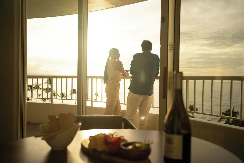 Guests on the lanai of the Kilohana Corner Suite at Fairmont Kea Lani Maui overlooking the ocean.