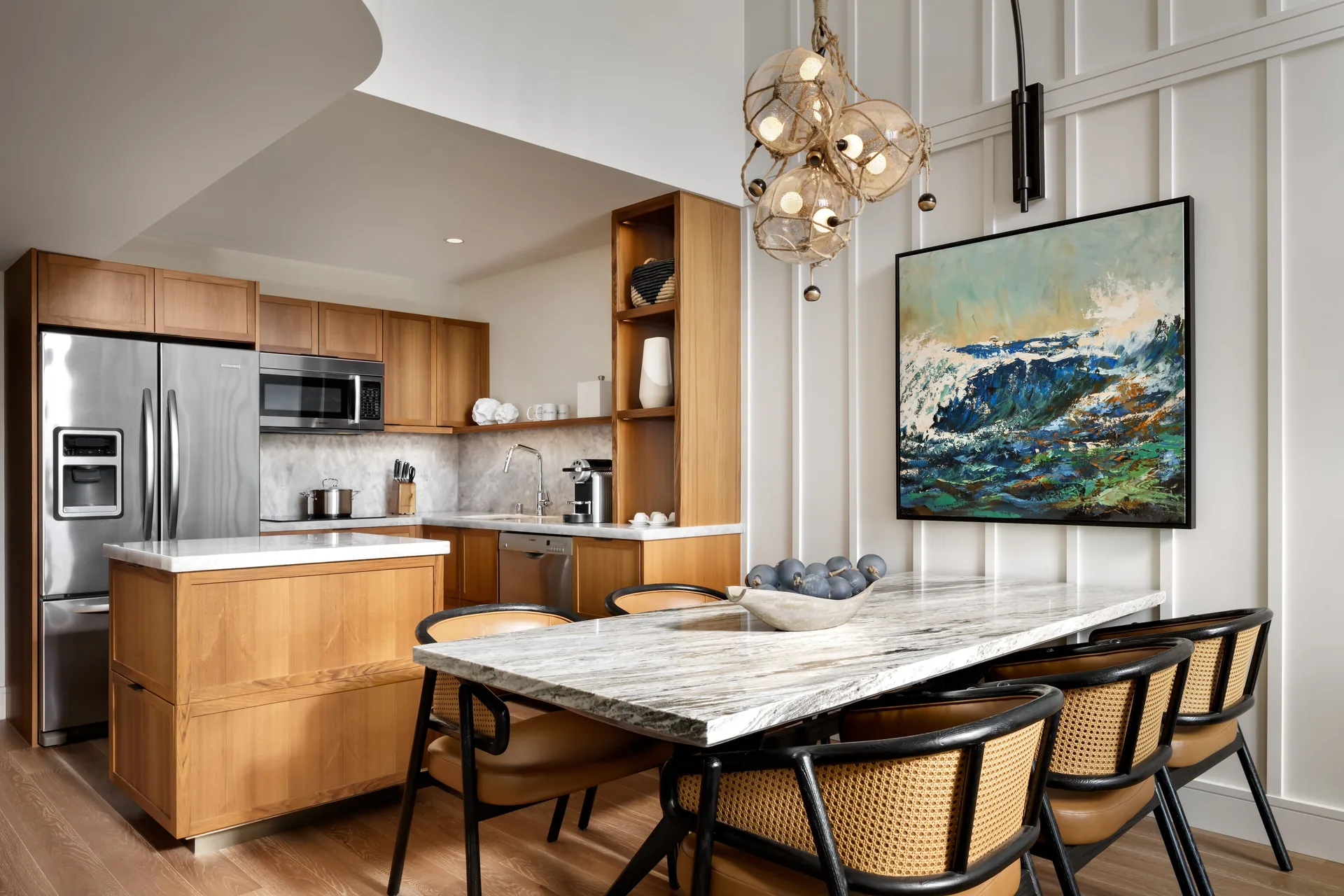 Luxury villa kitchen and dining area at Fairmont Kea Lani Maui with wood cabinetry and marble table.