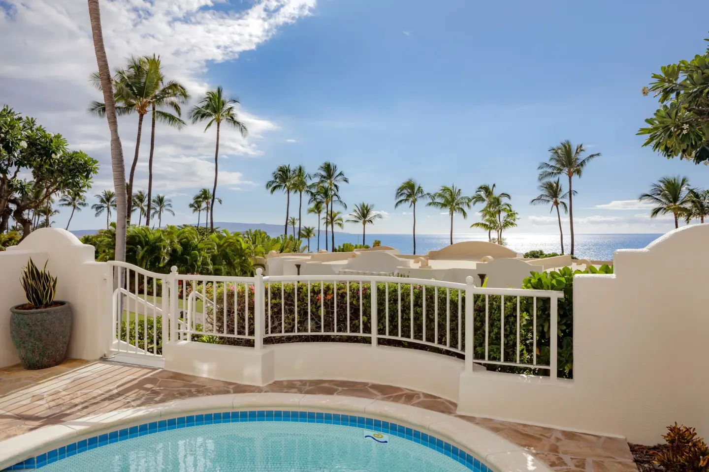 Ocean view from a luxury villa pool terrace at Fairmont Kea Lani Maui with palms and white railing.