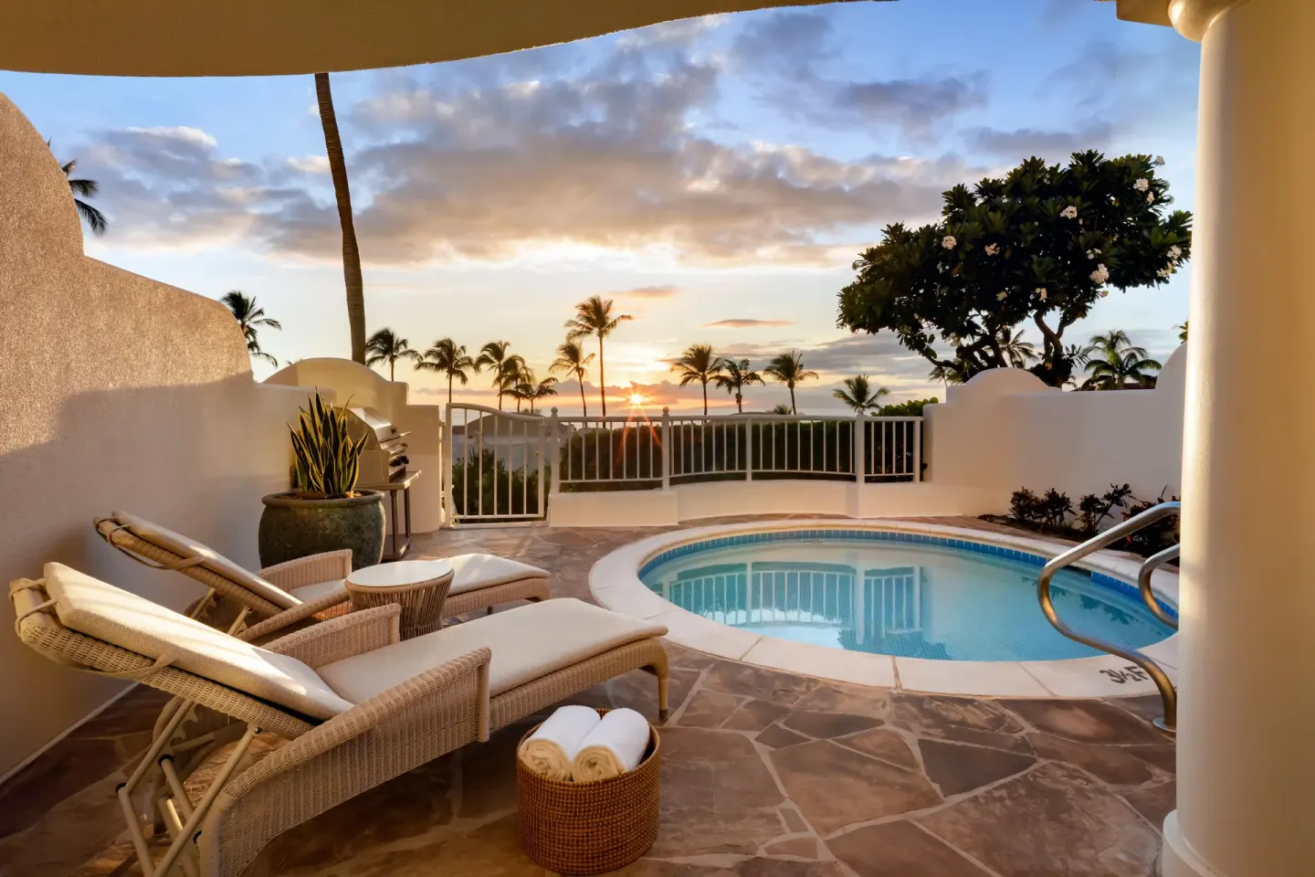 Luxury villa terrace at Fairmont Kea Lani Maui with plunge pool, loungers, palms, and ocean sunset.
