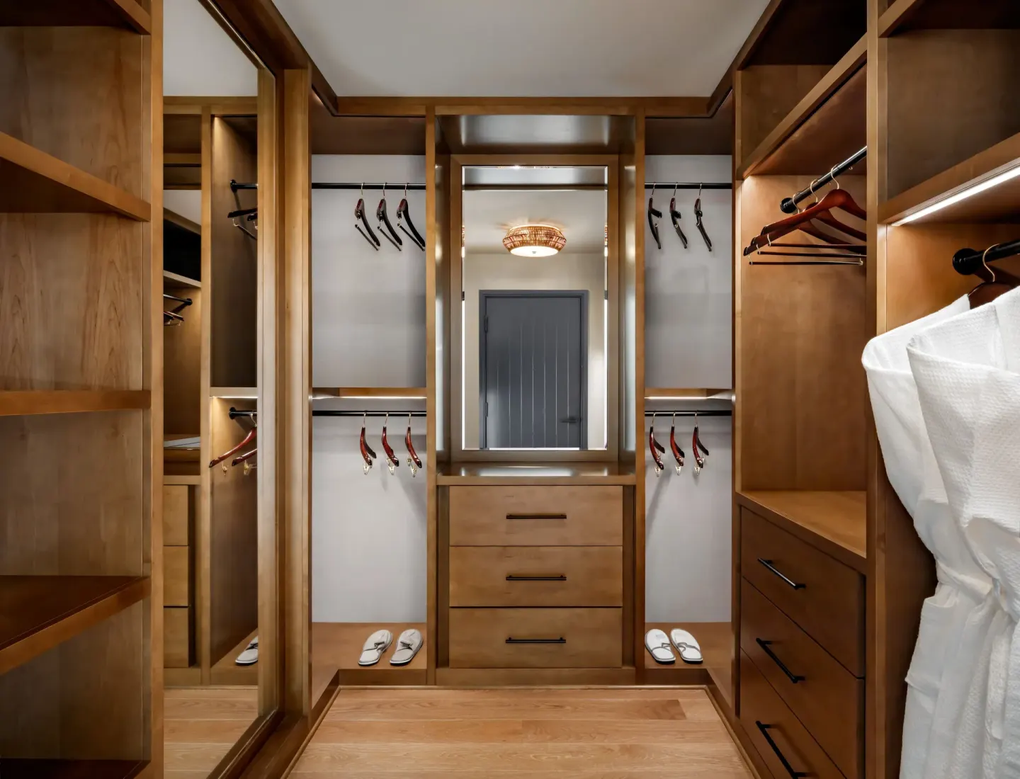 Walk-in closet in a luxury villa at Fairmont Kea Lani Maui with wood shelving, mirror, and robes.