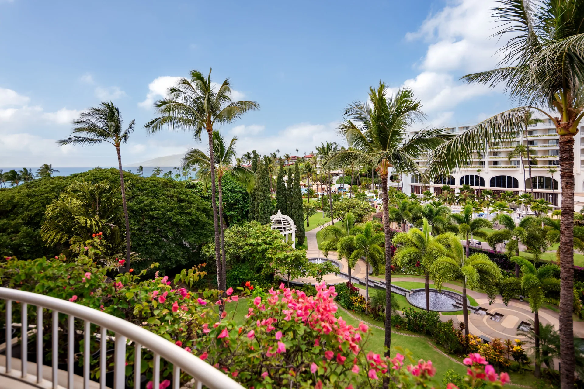 Partial ocean view suite balcony overlooks palms and gardens at Fairmont Kea Lani Maui.