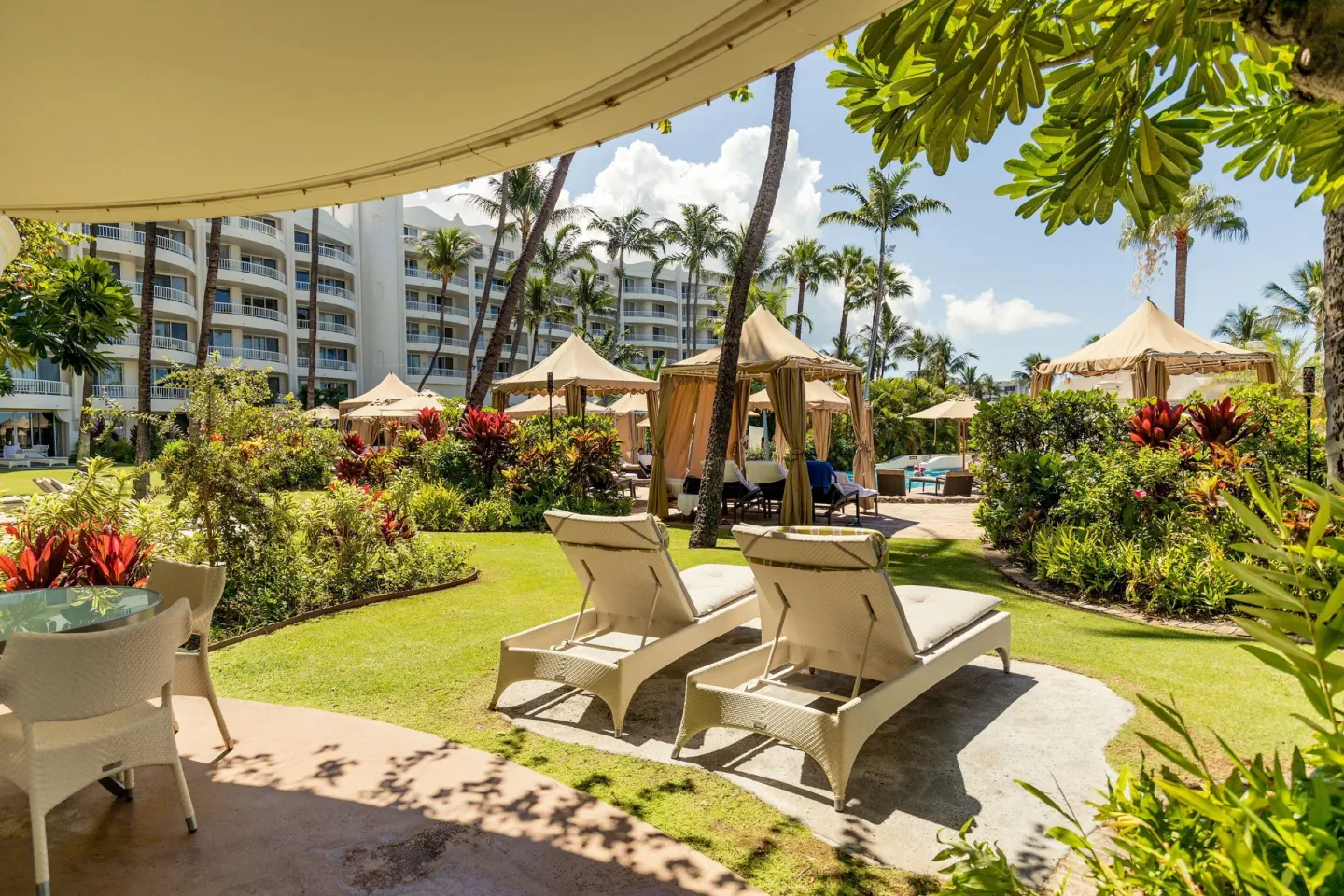 Poolside Suite lanai with chaise lounges and garden cabanas at Fairmont Kea Lani Maui.