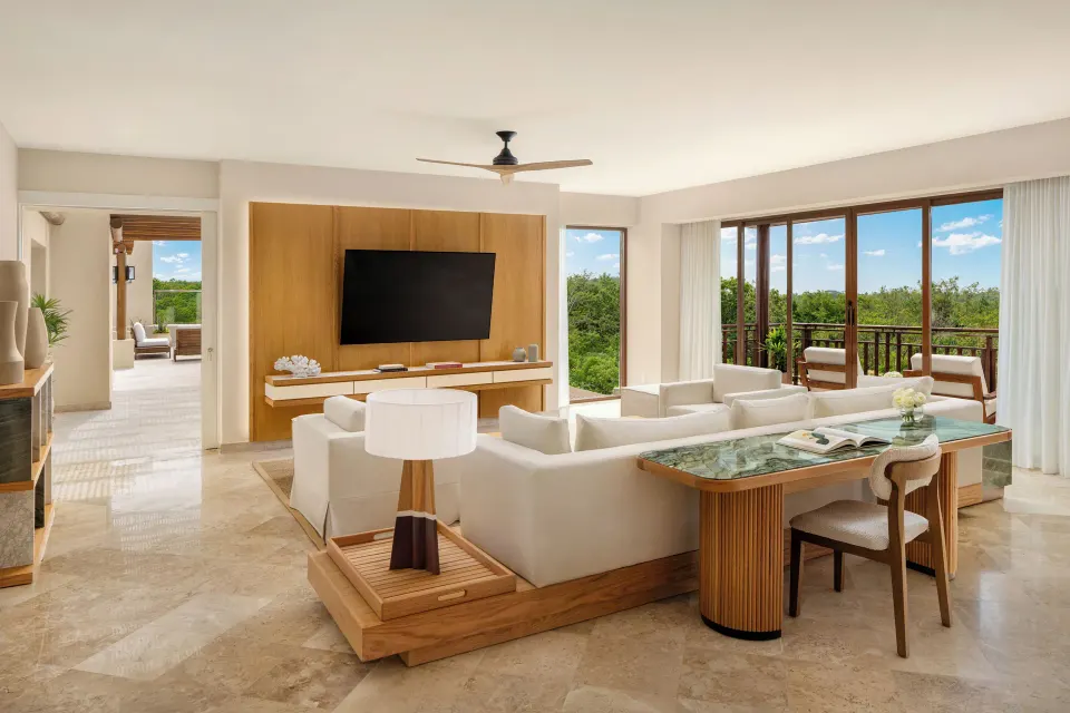 Bambu Suite living room with balcony and resort greenery at Fairmont Mayakoba.