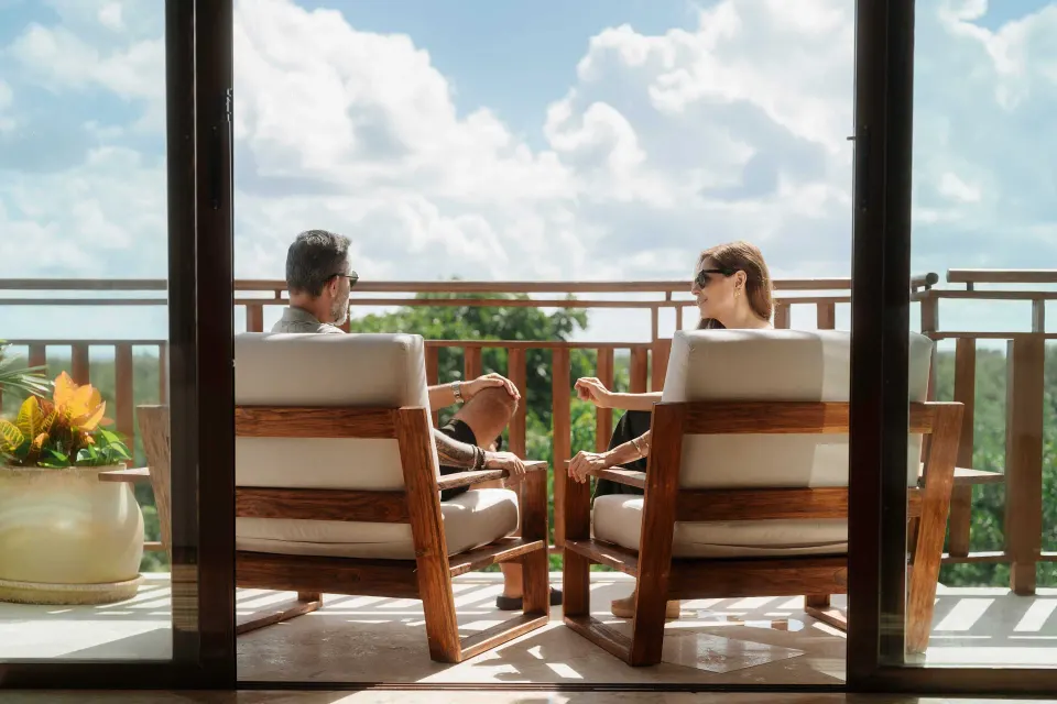 Private balcony view with two chairs overlooking trees and water at Fairmont Mayakoba.