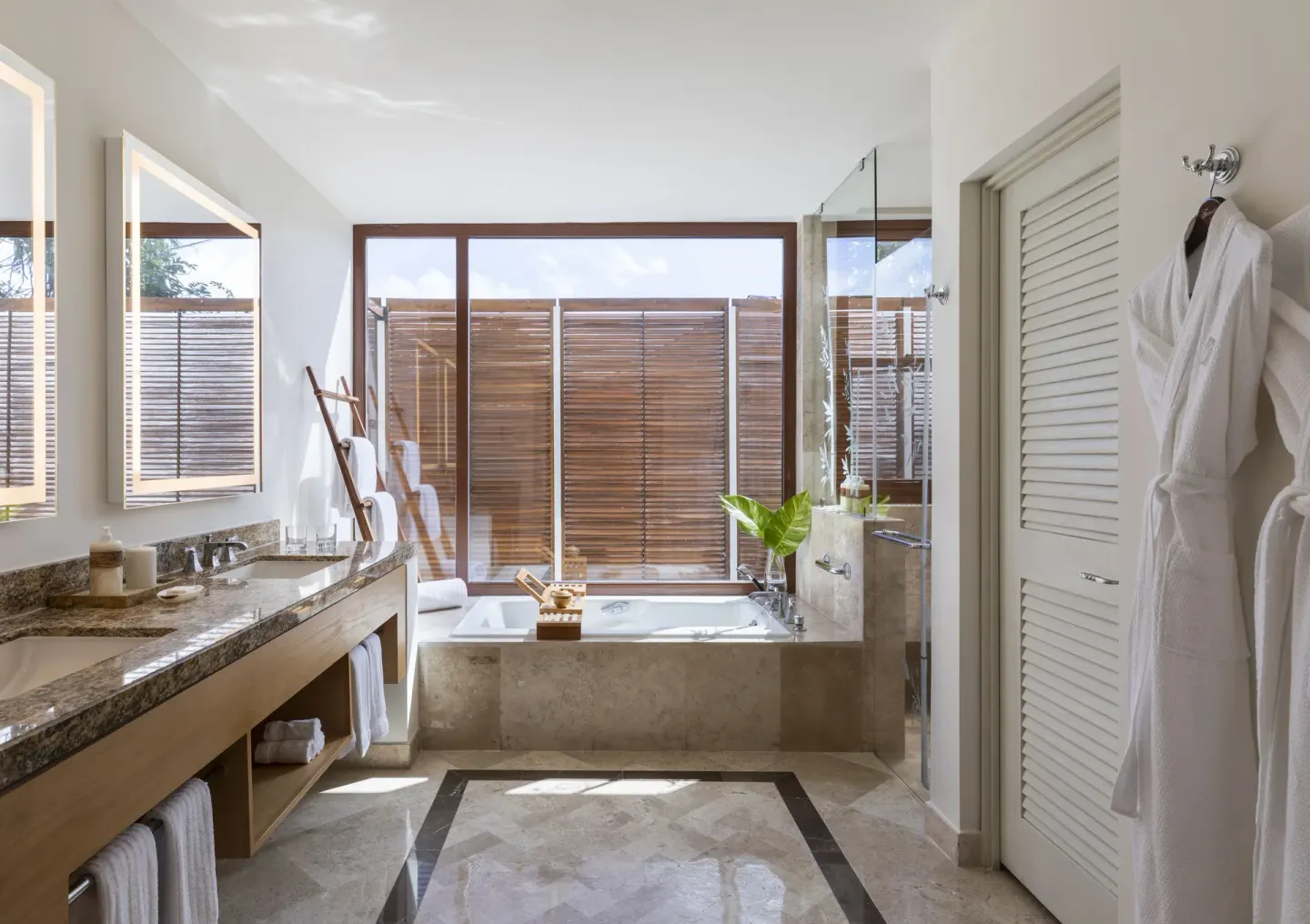 Bathroom in a Casita Deluxe Room at Fairmont Mayakoba with soaking tub, double vanity, and robes.