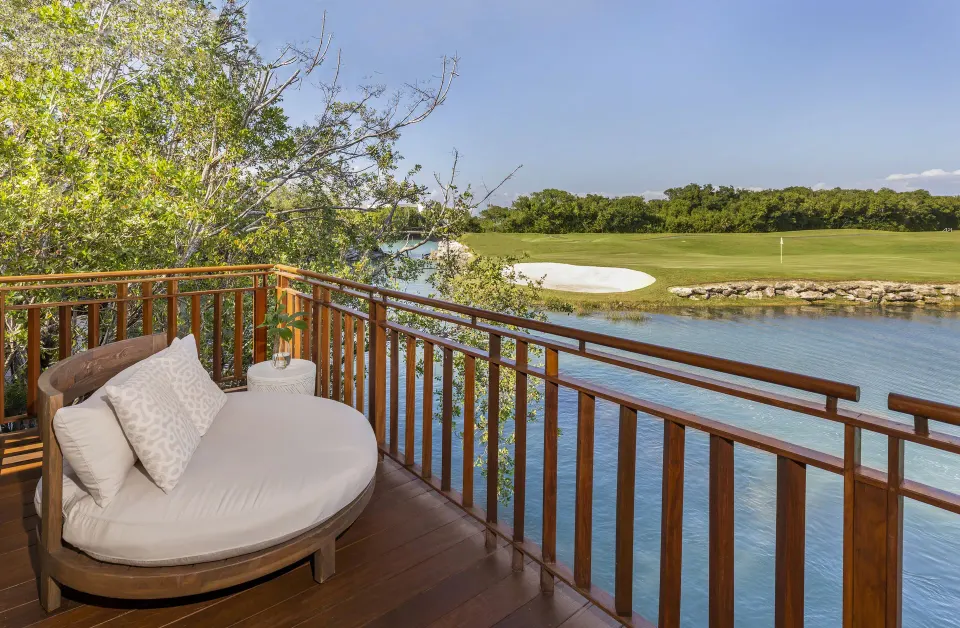 Casita Signature Room balcony at Fairmont Mayakoba with a round daybed overlooking water and golf greens.