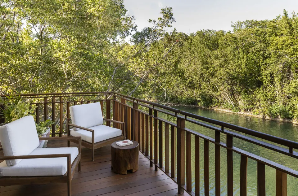 Canal-view balcony with cushioned chairs at Fairmont Mayakoba.