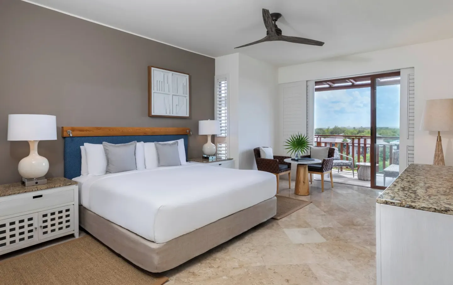 Fairmont Mayakoba at Fairmont Mayakoba with a king bed, nightstands, balcony seating, and a ceiling fan.