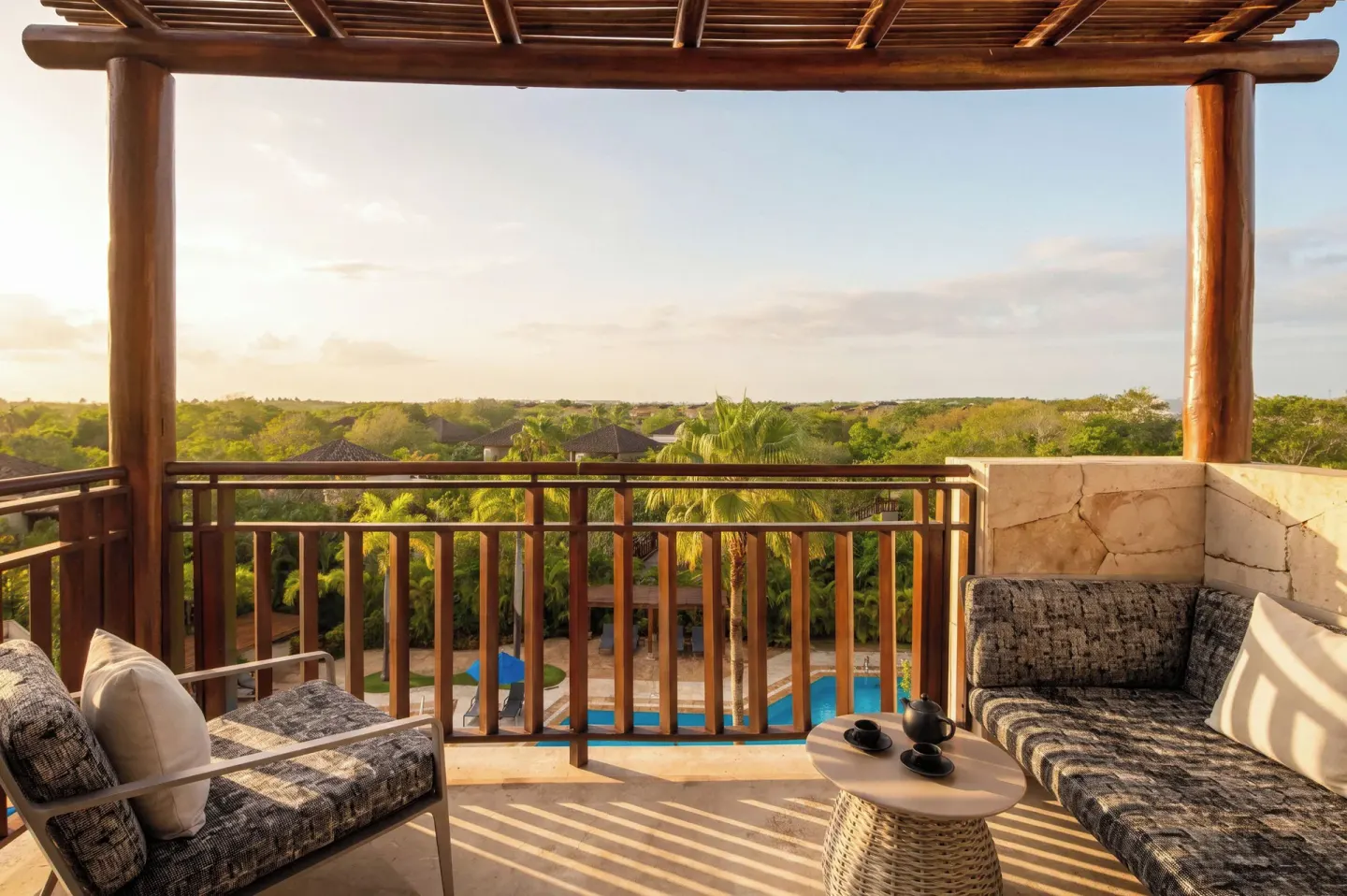 Fairmont Mayakoba balcony at Fairmont Mayakoba with cushioned seating, a small table, and treetop views.