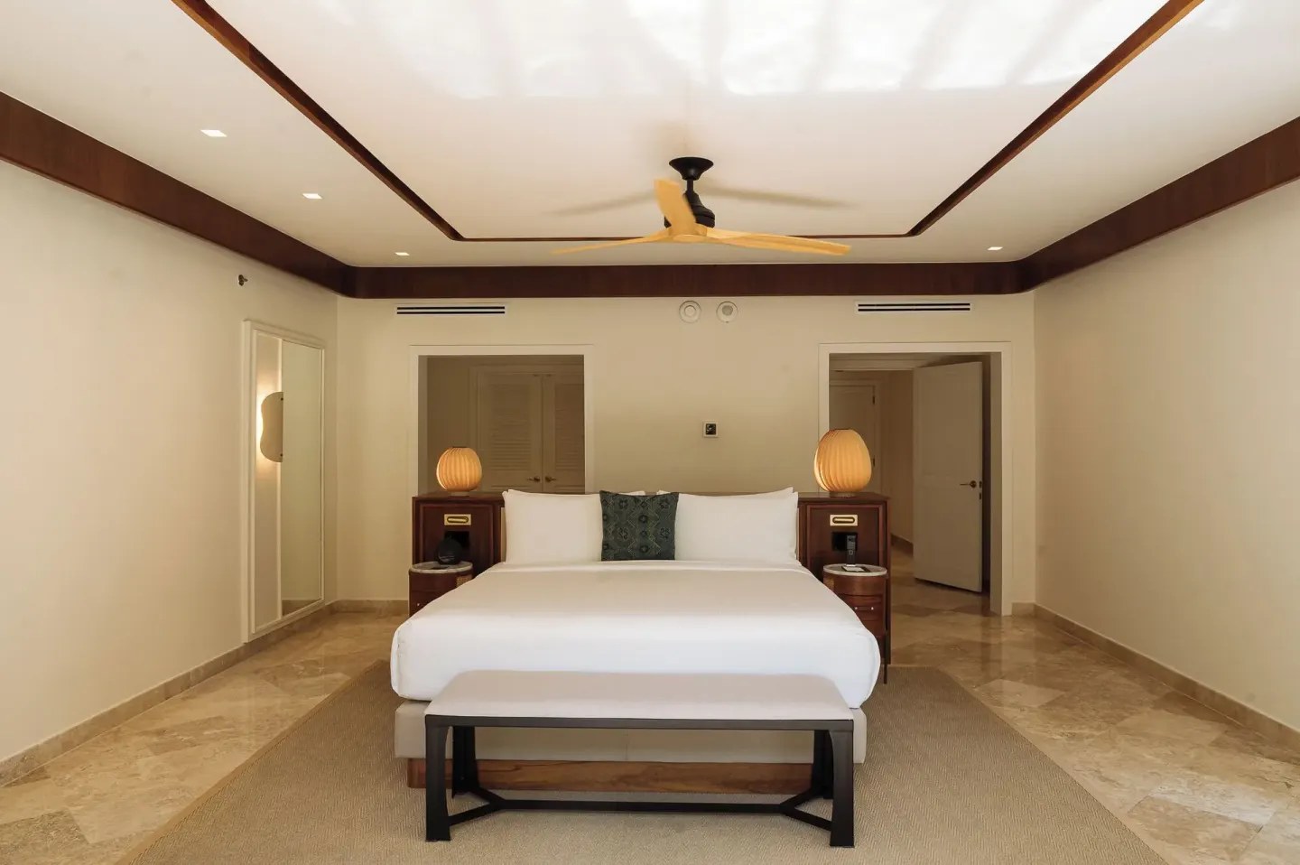 Presidential Suite king bedroom with bench and lamps at Fairmont Mayakoba.