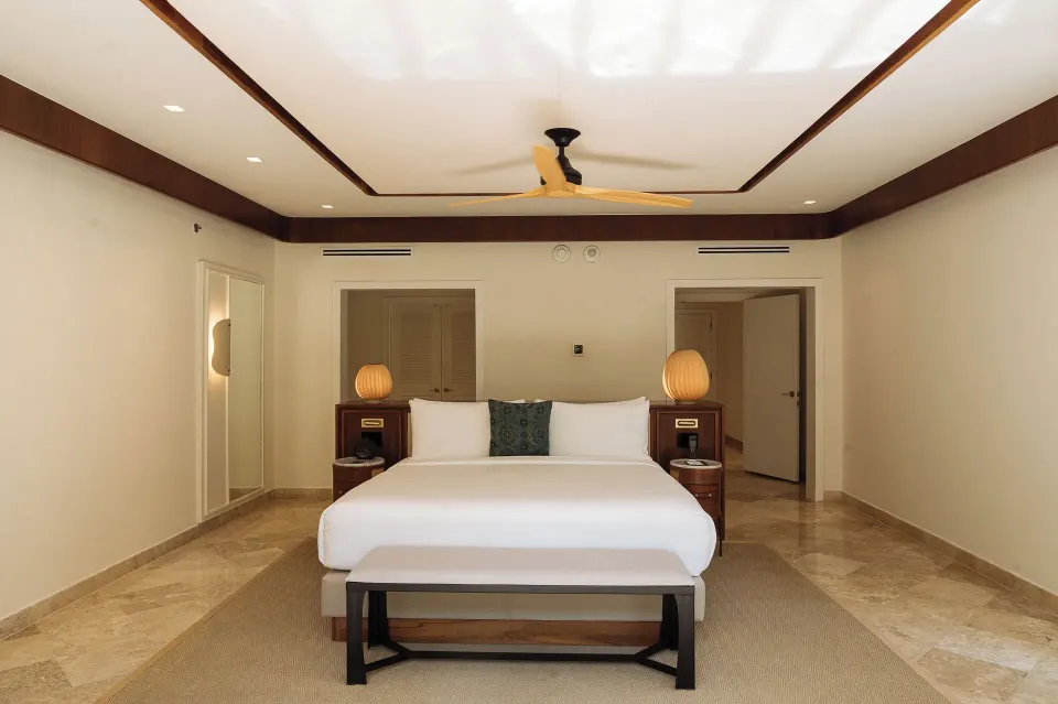 Presidential Suite king bedroom with bench and lamps at Fairmont Mayakoba.