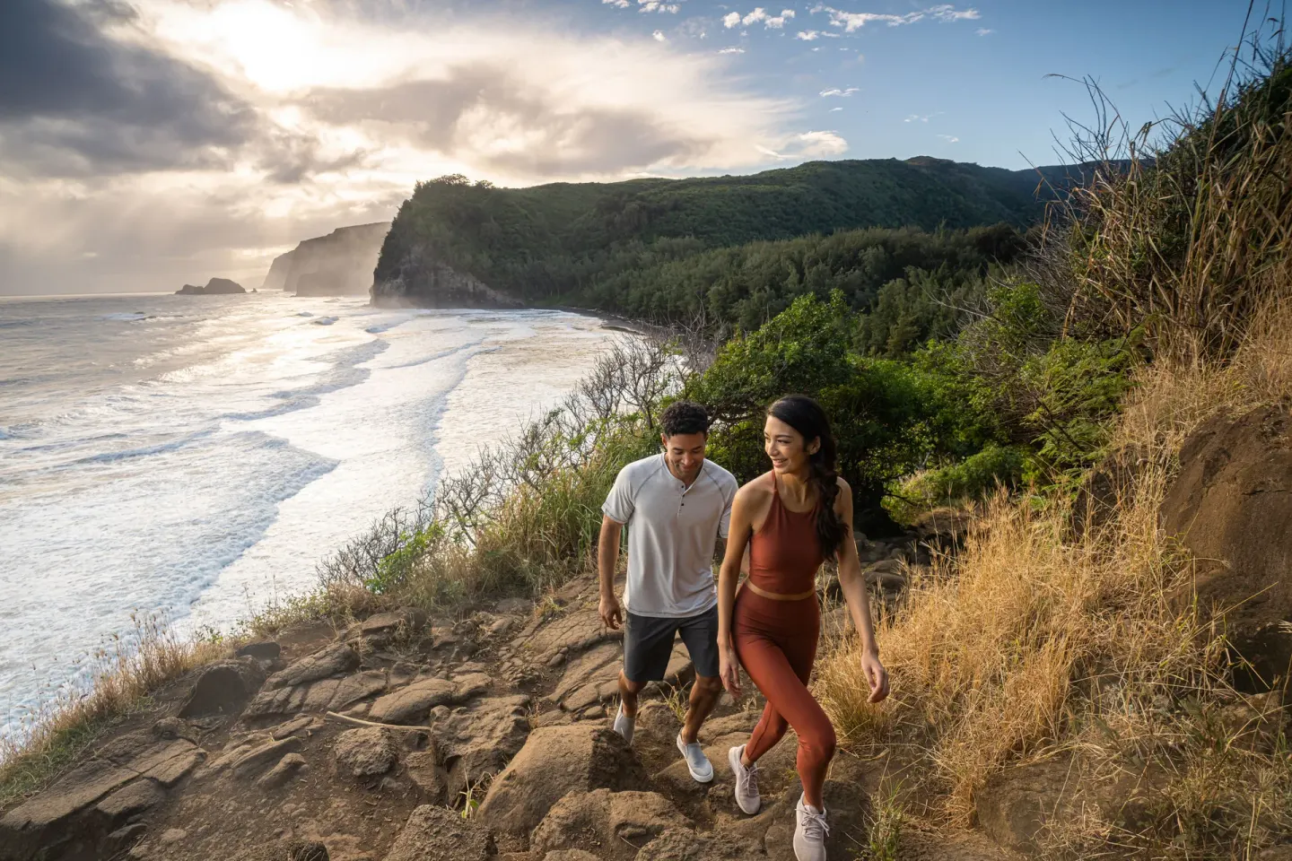 Two hikers walk a coastal cliff trail near Fairmont Orchid.
