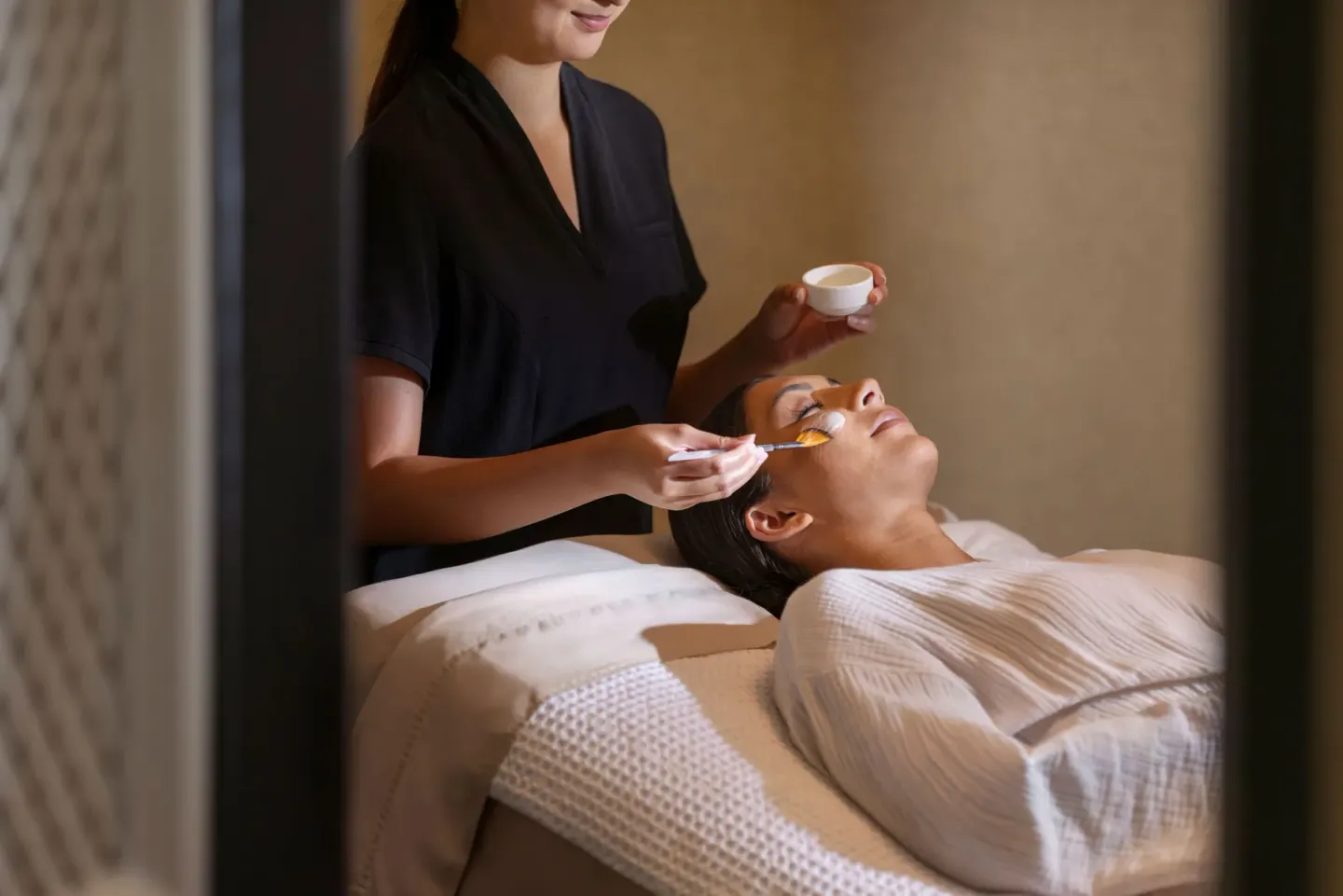 A spa therapist applies a facial treatment to a guest at Fairmont Orchid.