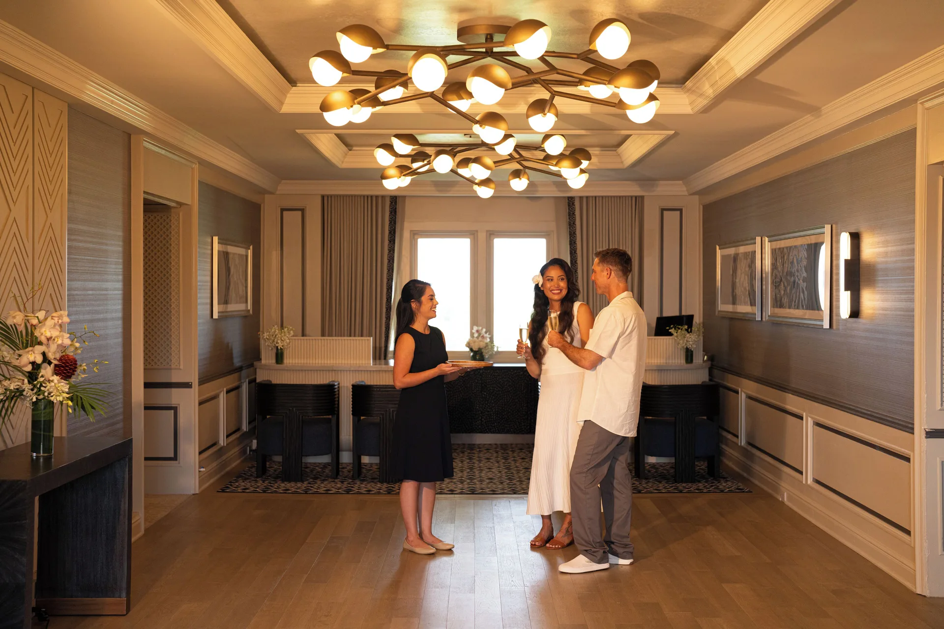 Guests speaking with a staff member in a reception room at Fairmont Orchid.