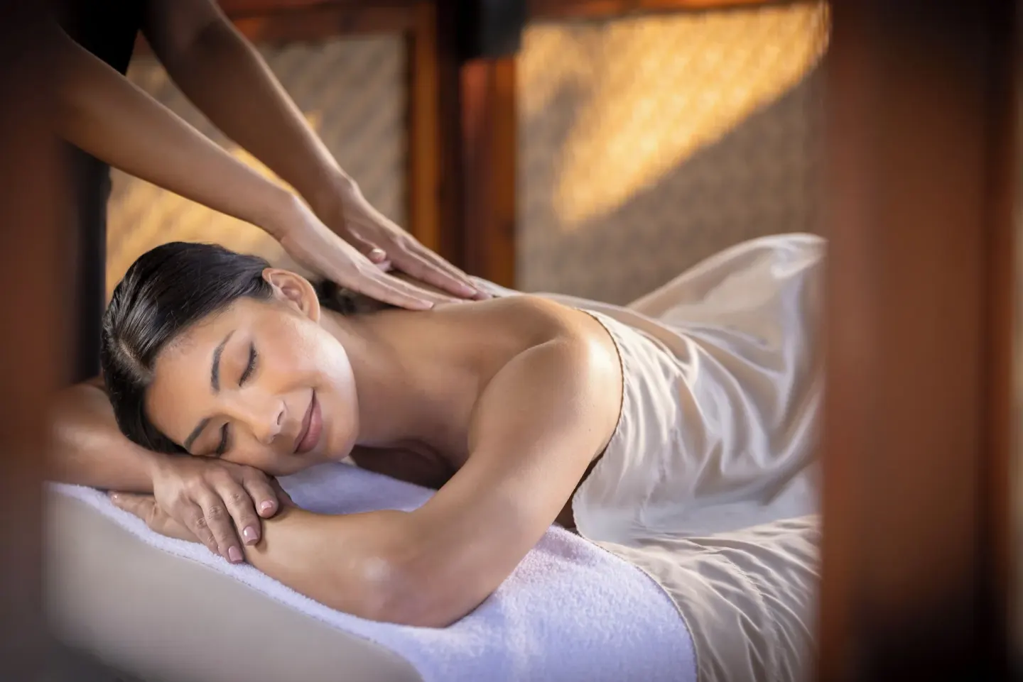 A guest receives a back massage on a spa treatment bed at Fairmont Orchid.