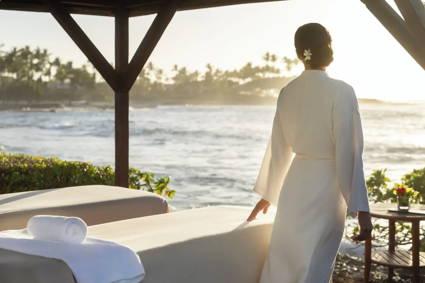 A robed guest stands by oceanfront spa loungers at Fairmont Orchid.