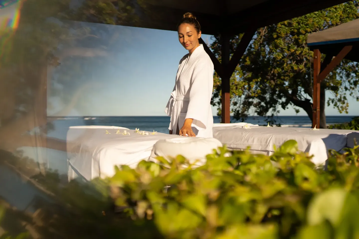 Outdoor massage tables with flowers are set near the ocean at Fairmont Orchid.