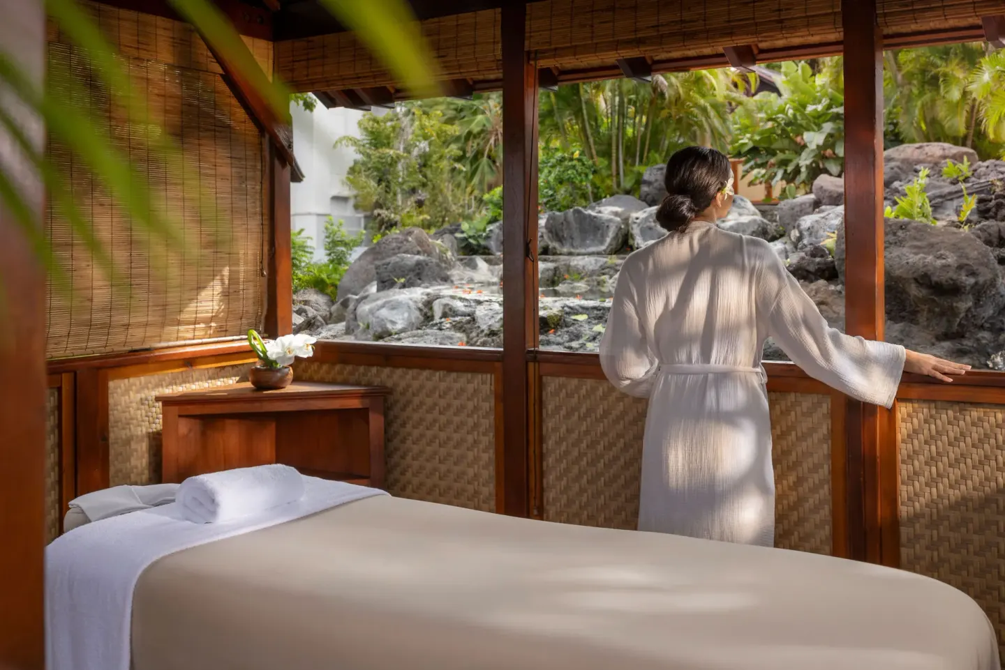 A robed guest looks out from a spa treatment cabana at Fairmont Orchid.