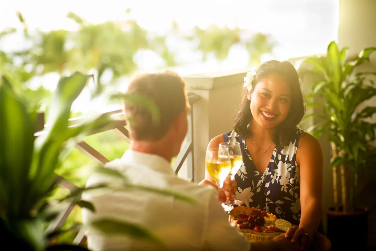 Couple sharing drinks and a platter on a shaded lanai at Fairmont Orchid.