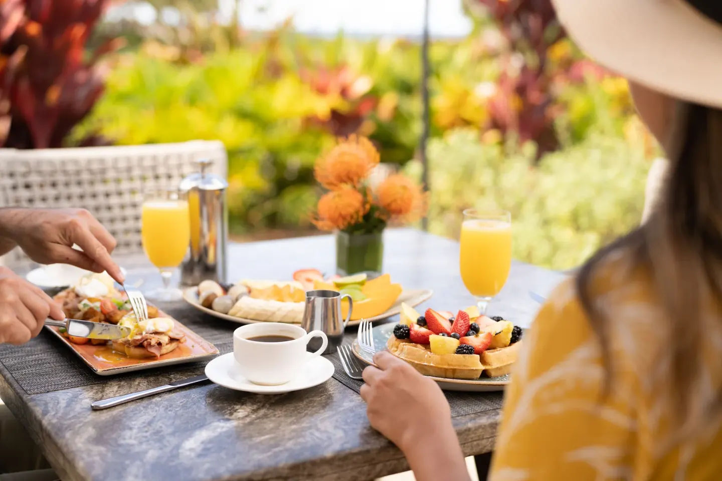 Outdoor breakfast with waffles, fruit, coffee, and orange juice at Fairmont Orchid.