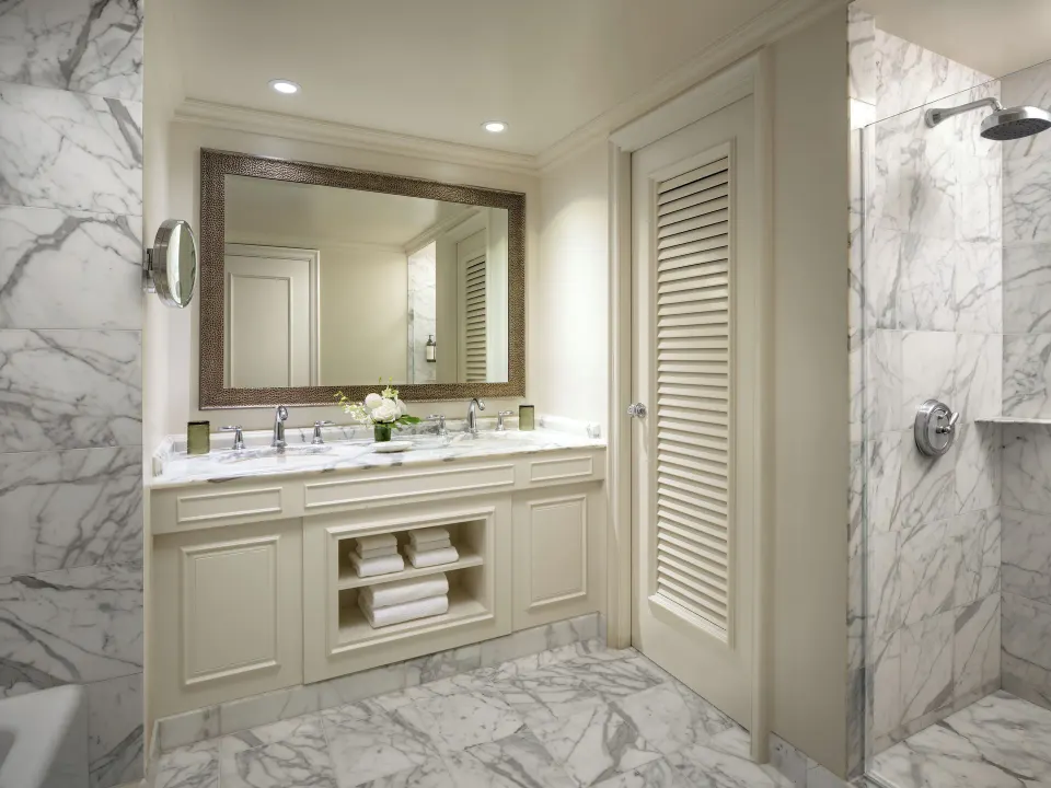 Fairmont Orchid guest bathroom with double vanity, marble surfaces, and glass shower.