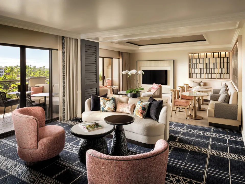 Fairmont Orchid lounge with sofas, tables, TV, and balcony views of palms.