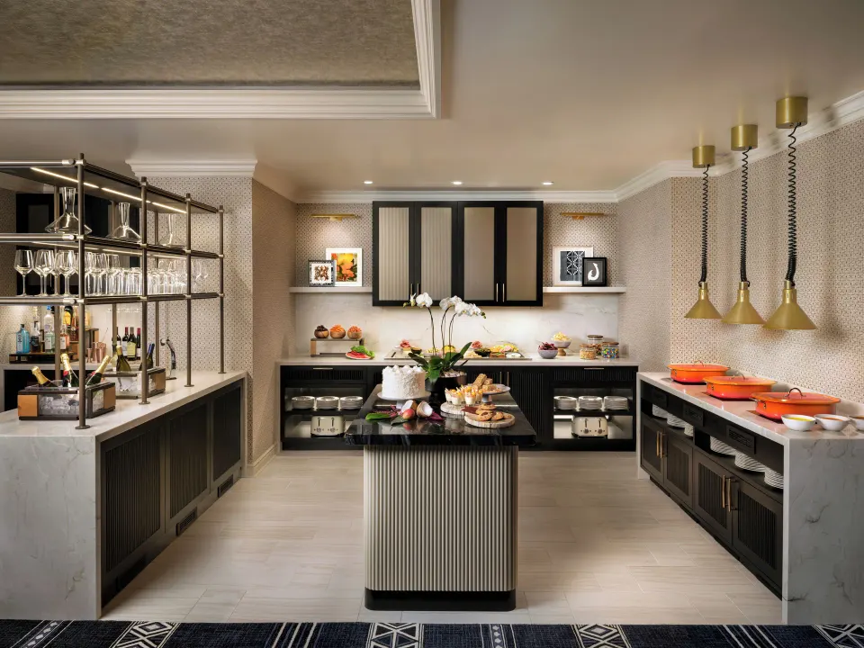 Fairmont Orchid lounge buffet with serving islands, cookware, glassware, and snacks.