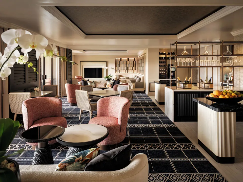Fairmont Orchid lounge seating with buffet counter, glassware, and soft chairs.