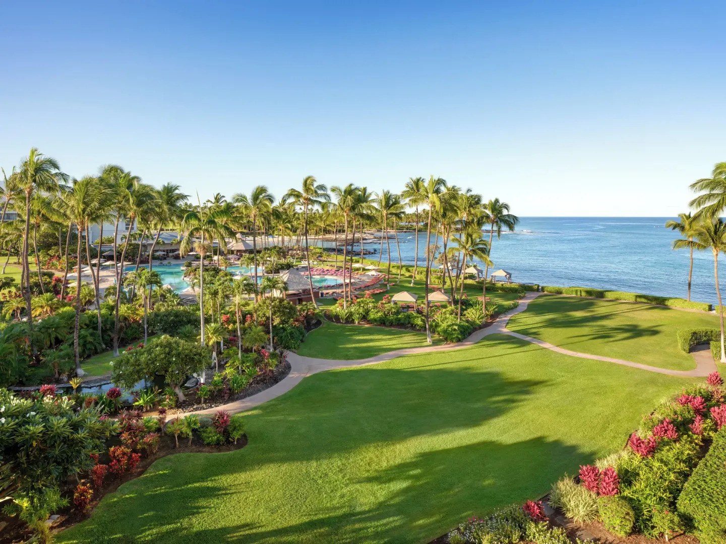Oceanfront gardens, palms, and pool area viewed from Fairmont Orchid.