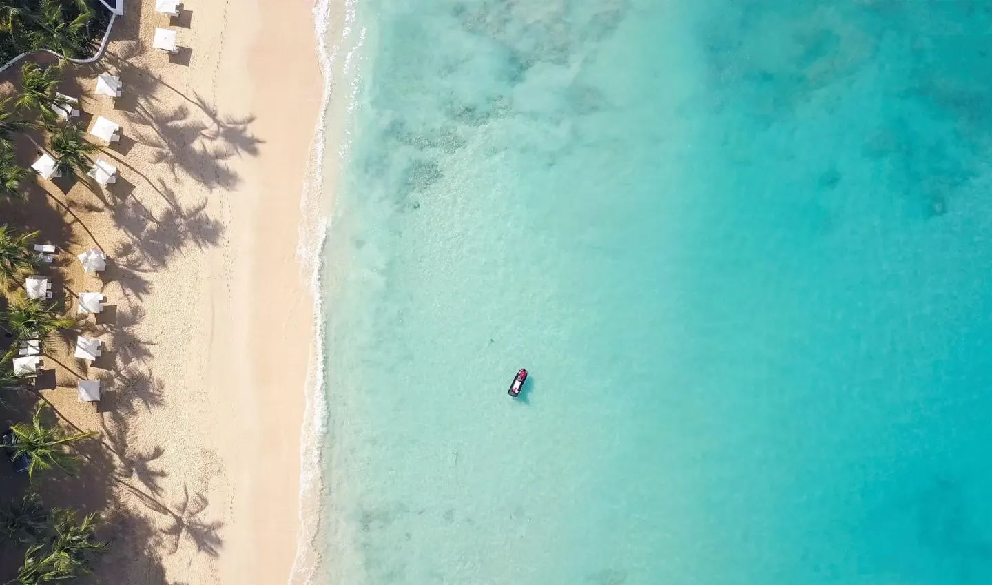 Aerial view of the sandy beach and turquoise water at Fairmont Royal Pavilion.