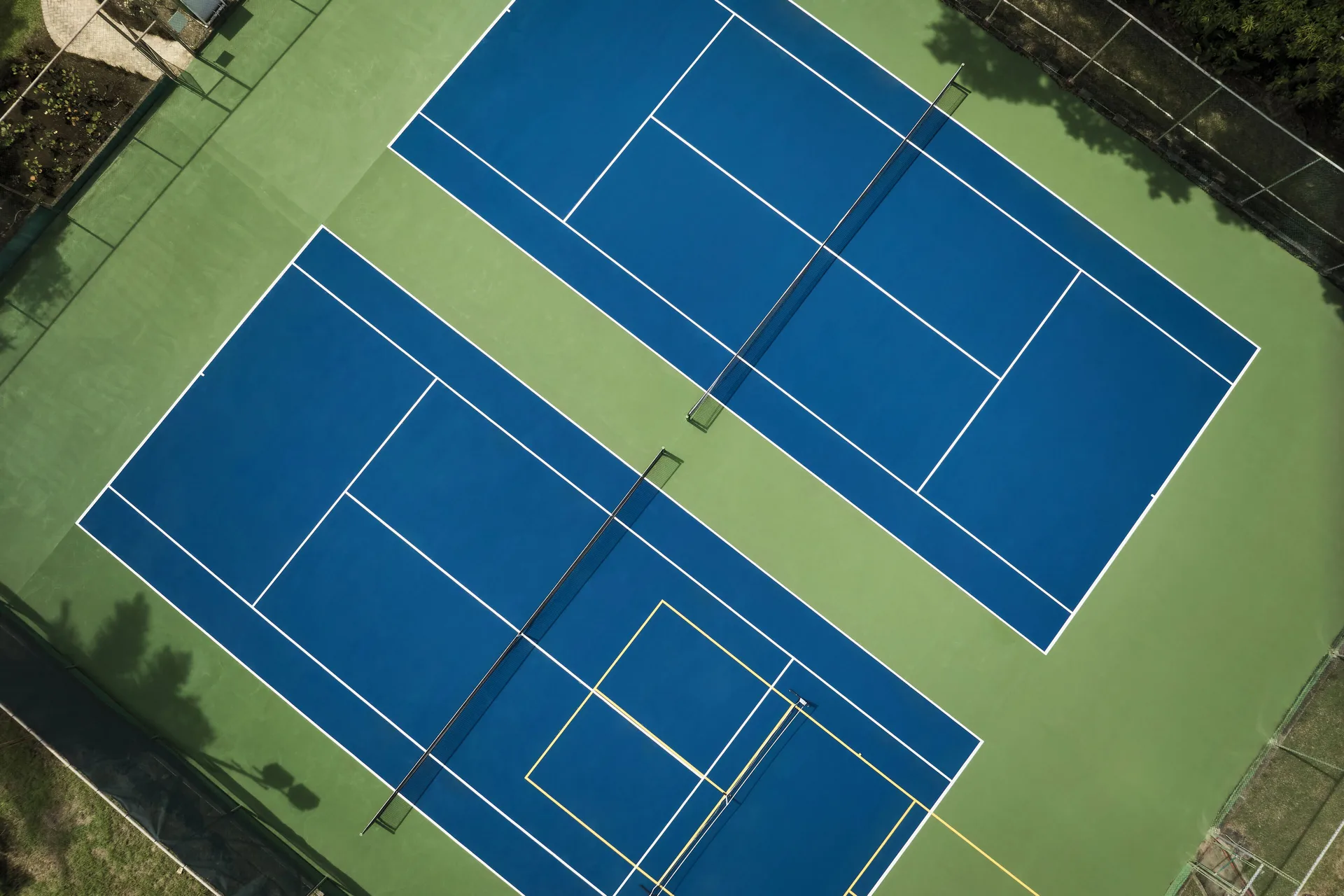 Aerial view of blue tennis and pickleball courts at Fairmont Royal Pavilion.