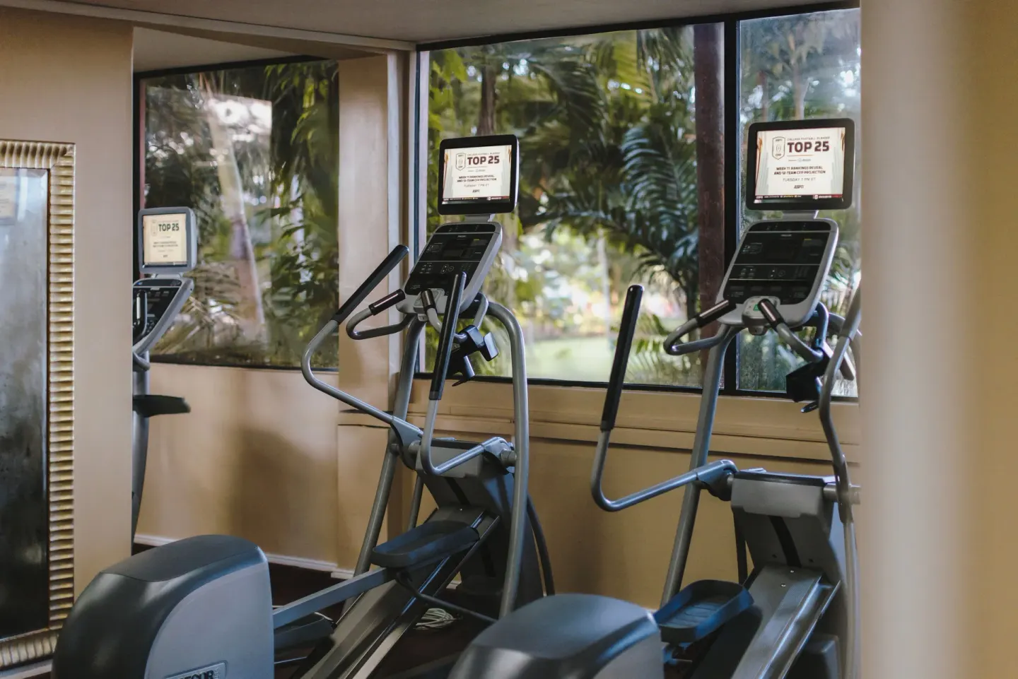 Fitness room cardio machines by garden-facing windows at Fairmont Royal Pavilion.