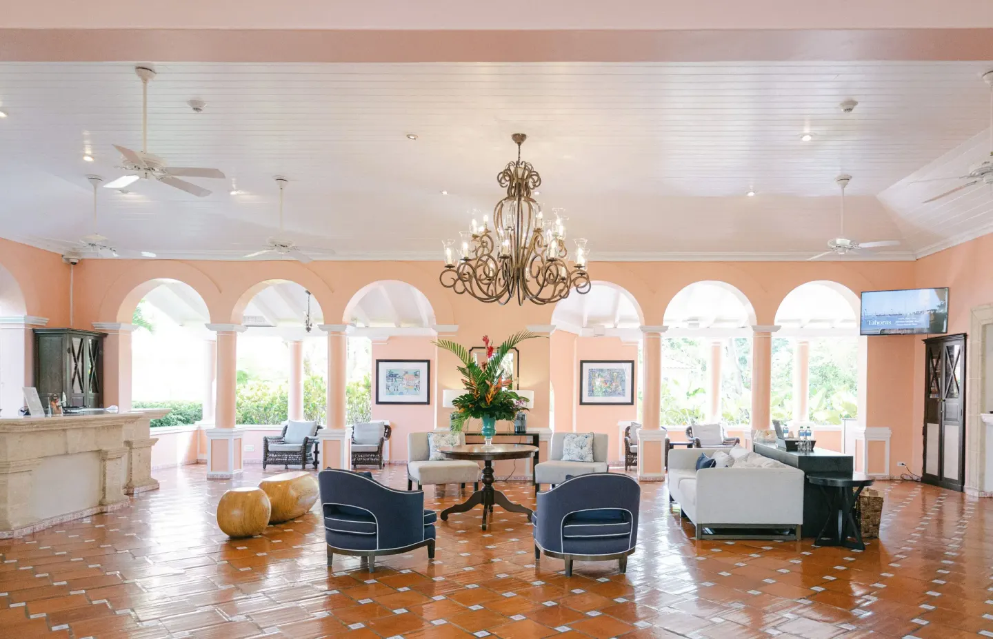 Open lobby lounge with arches, seating, and chandelier at Fairmont Royal Pavilion.