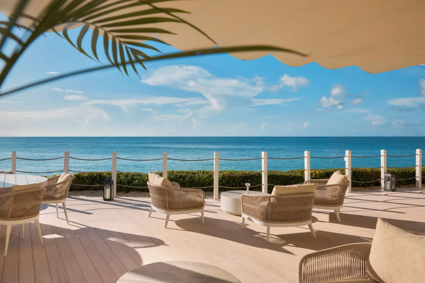 Oceanfront terrace seating and blue water at Fairmont Royal Pavilion.