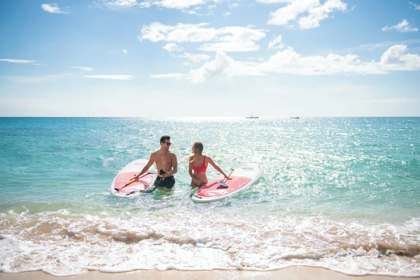 Two paddleboarders at the shoreline at Fairmont Royal Pavilion.