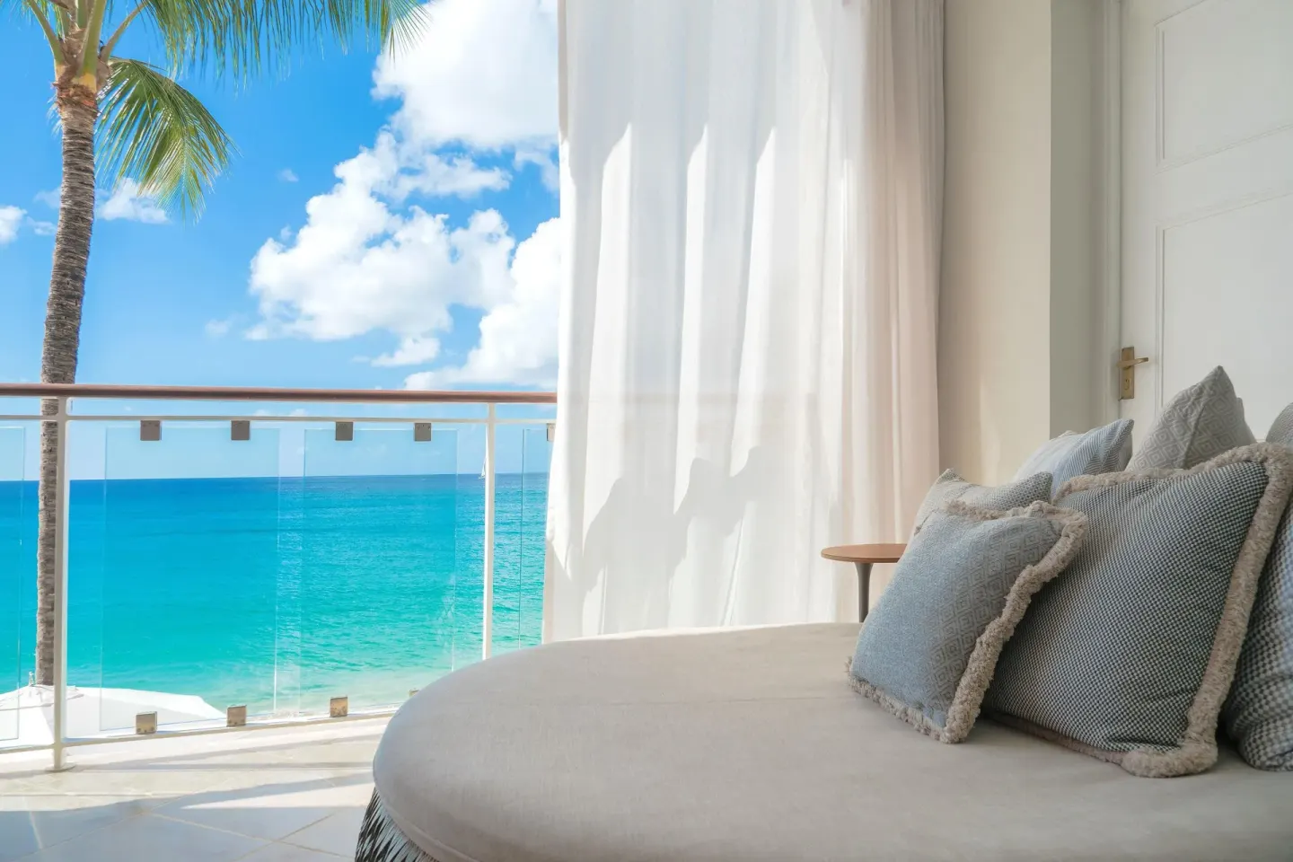 Luxury Room Oceanfront balcony daybed with palm and sea view at Fairmont Royal Pavilion.