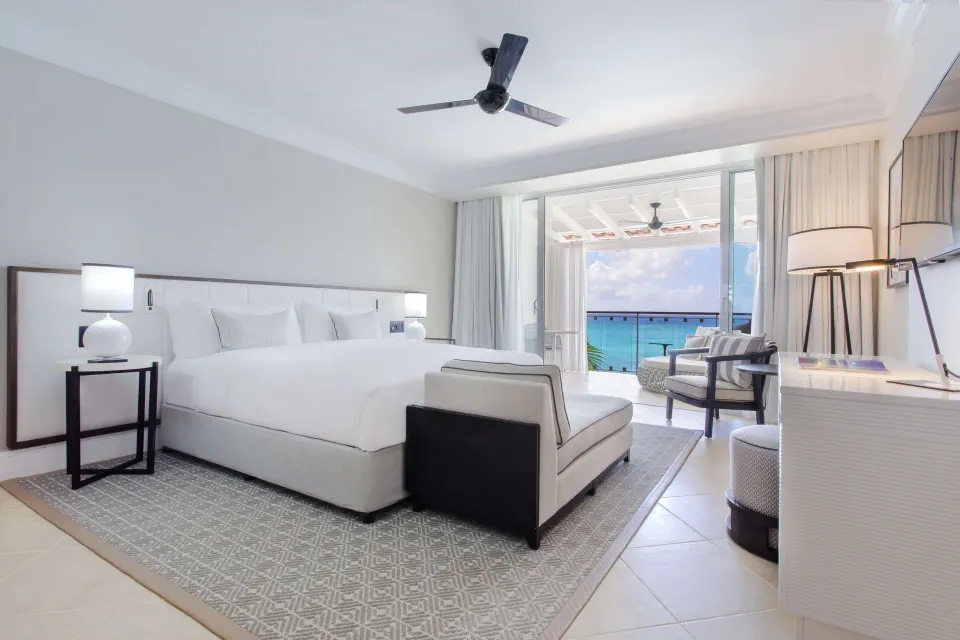 Luxury Room Oceanfront king bed with chaise and sea-facing balcony at Fairmont Royal Pavilion.