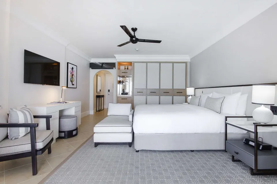 Luxury Room Oceanfront with king bed, chaise, desk and wall TV at Fairmont Royal Pavilion.