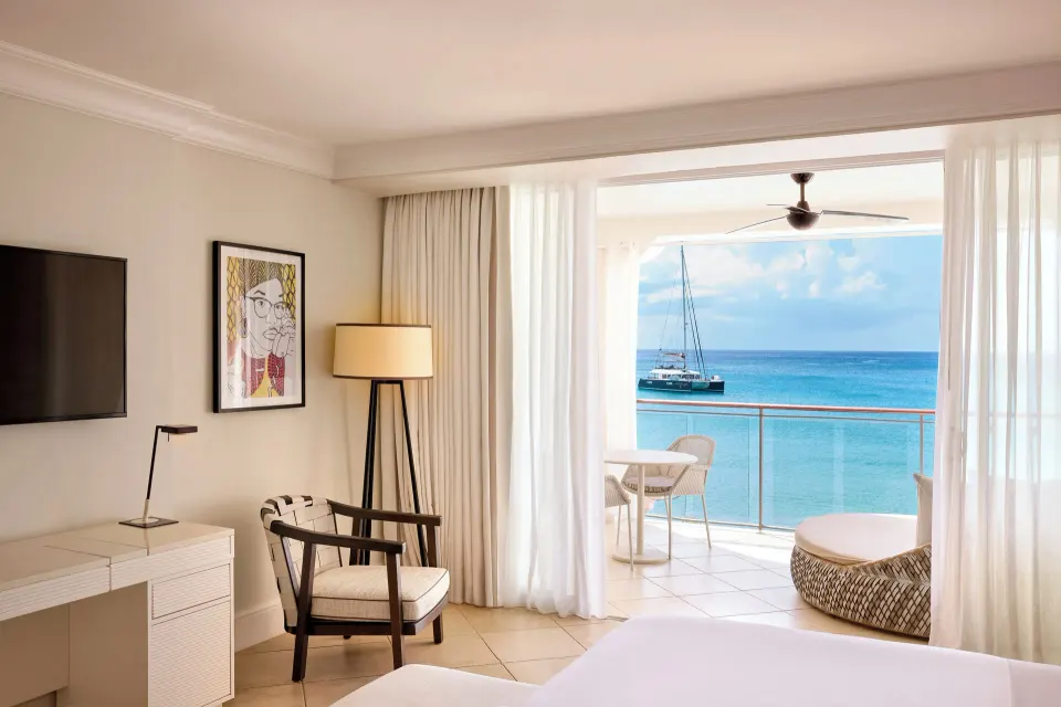 Luxury Room Oceanfront with balcony seating and catamaran view at Fairmont Royal Pavilion.