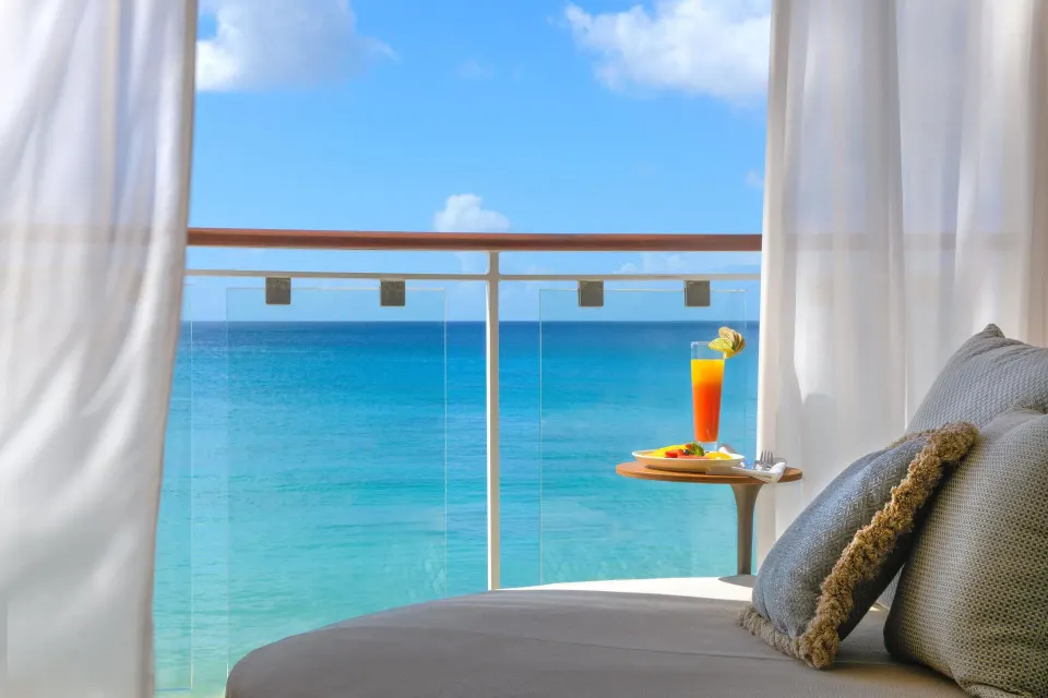 Oceanfront daybed and drink beside the balcony rail at Fairmont Royal Pavilion.
