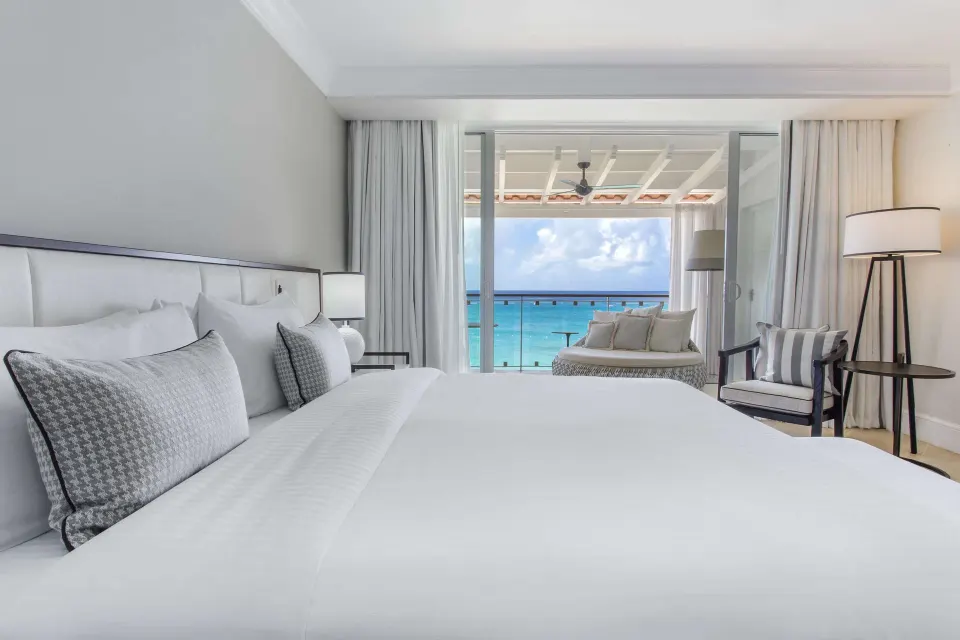 Signature Room king bed facing an oceanfront balcony at Fairmont Royal Pavilion.